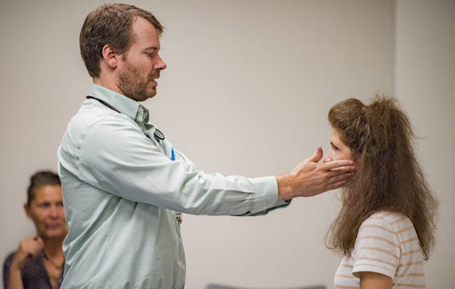 Shepherd Center physician performing a medical exam on a brain injury patient